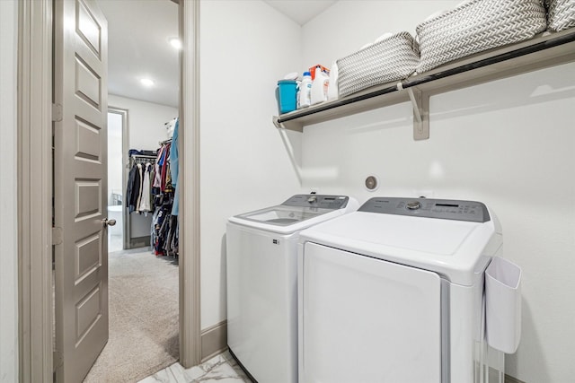 clothes washing area featuring washer and clothes dryer and light colored carpet