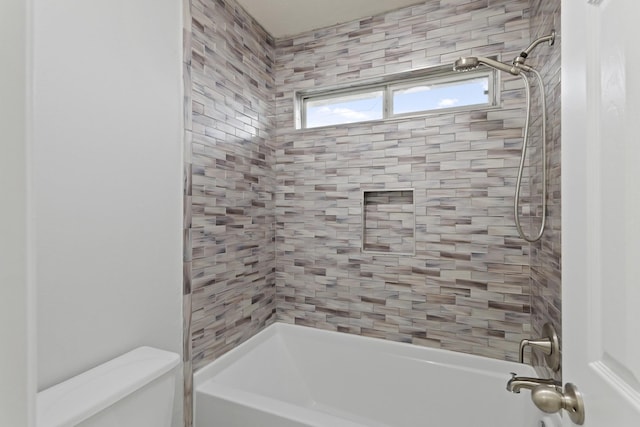 bathroom with tiled shower / bath and toilet