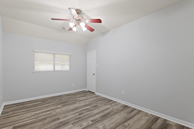 empty room featuring vaulted ceiling, wood-type flooring, and ceiling fan