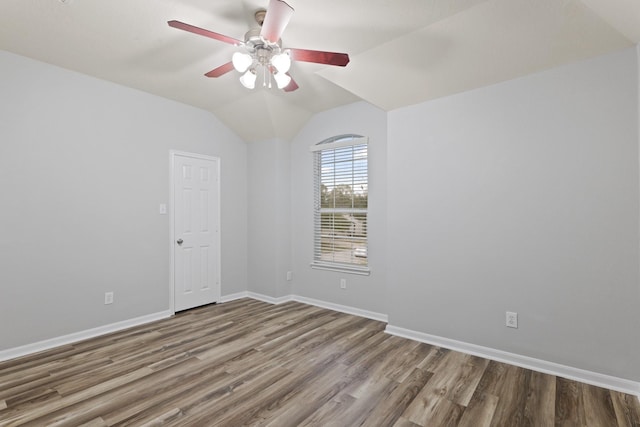 spare room with vaulted ceiling, light hardwood / wood-style floors, and ceiling fan