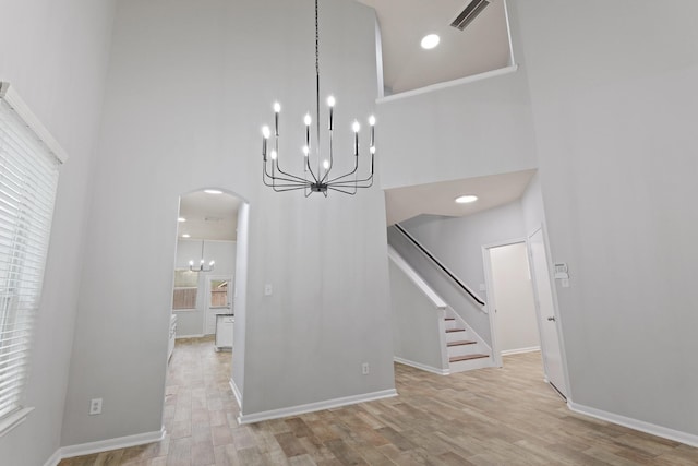 unfurnished dining area with light hardwood / wood-style floors and a high ceiling