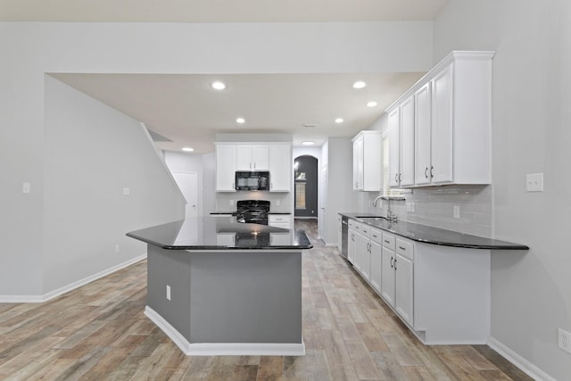 kitchen featuring sink, white cabinetry, tasteful backsplash, light hardwood / wood-style flooring, and black appliances