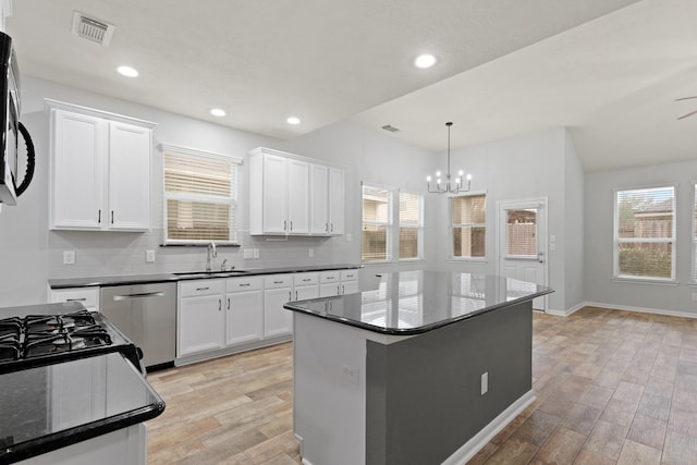 kitchen featuring white cabinetry, stainless steel dishwasher, sink, and pendant lighting