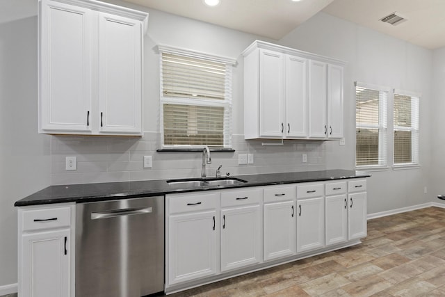 kitchen with tasteful backsplash, sink, white cabinets, stainless steel dishwasher, and light wood-type flooring