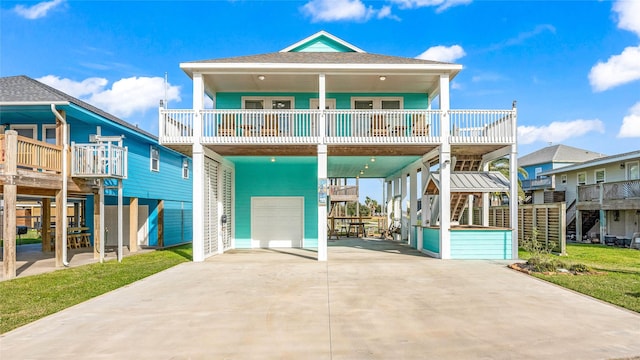 back of house featuring a balcony, a garage, and a carport