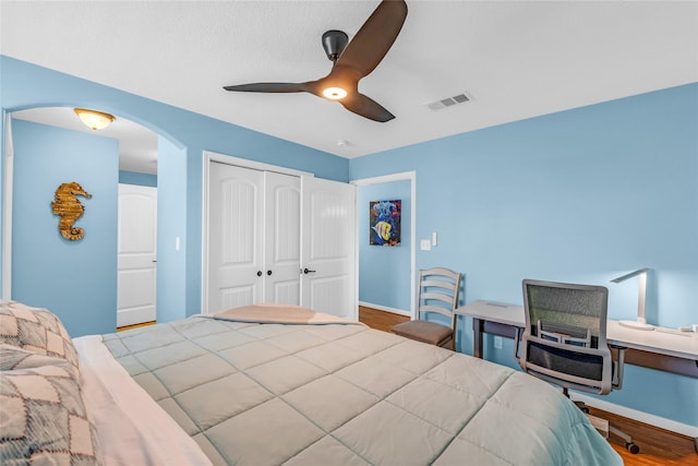 bedroom with ceiling fan, a closet, and hardwood / wood-style floors