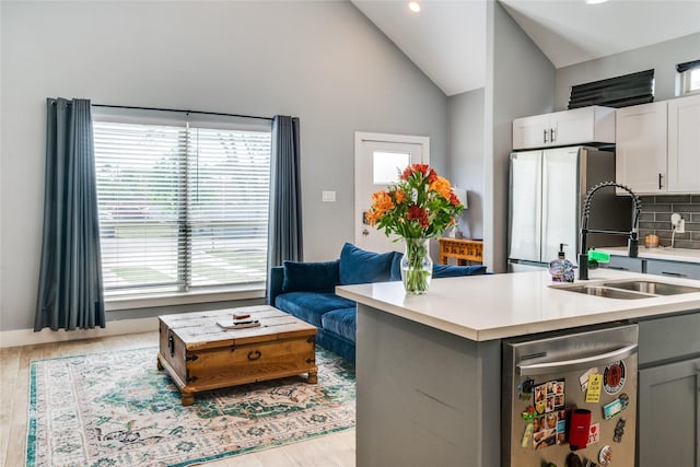 kitchen featuring sink, gray cabinets, stainless steel fridge, tasteful backsplash, and white cabinetry