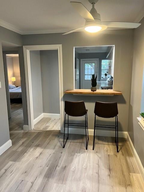 dining room with hardwood / wood-style flooring, ceiling fan, and ornamental molding