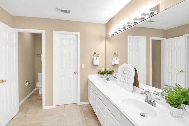 bathroom featuring tile patterned floors, vanity, and toilet