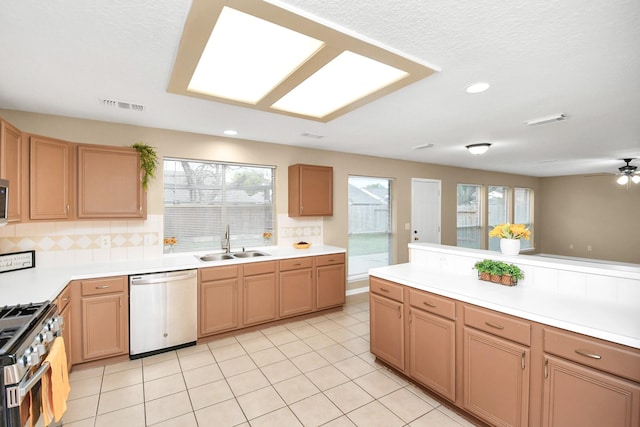 kitchen with backsplash, ceiling fan, sink, and appliances with stainless steel finishes