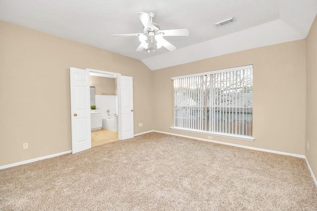 unfurnished bedroom with light carpet, connected bathroom, vaulted ceiling, and ceiling fan