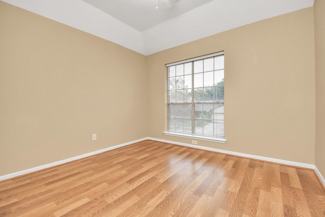 empty room with light wood-type flooring and vaulted ceiling