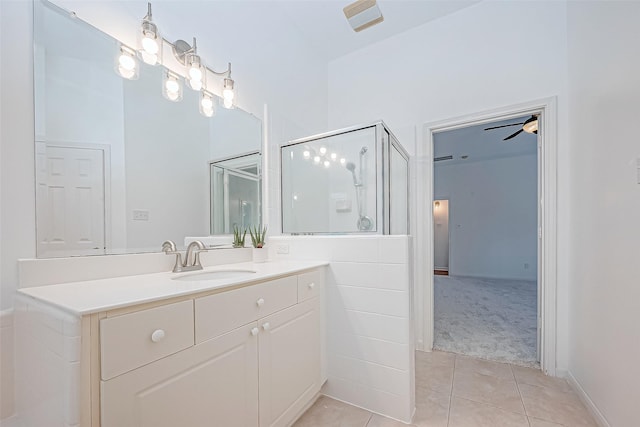 bathroom with tile patterned floors, ceiling fan, a shower with door, and vanity