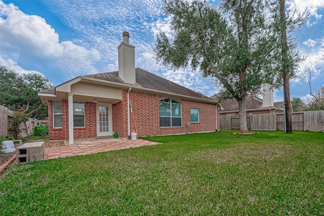 rear view of house with a patio area and a lawn