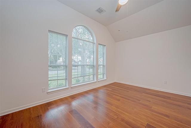 unfurnished room with ceiling fan, a healthy amount of sunlight, vaulted ceiling, and light hardwood / wood-style flooring