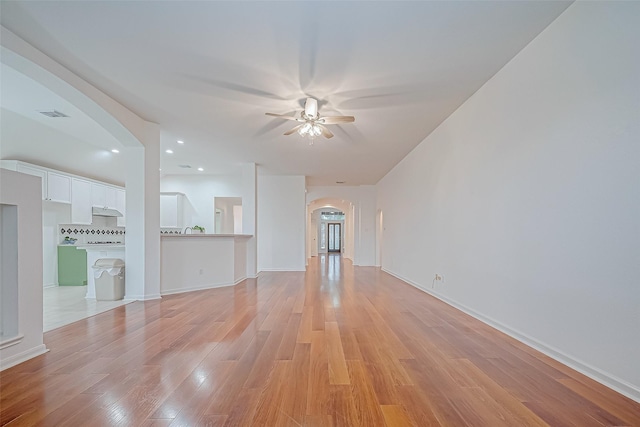 unfurnished living room featuring ceiling fan and light wood-type flooring