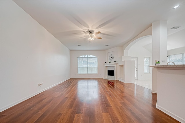 unfurnished living room featuring a wealth of natural light, hardwood / wood-style floors, and ceiling fan