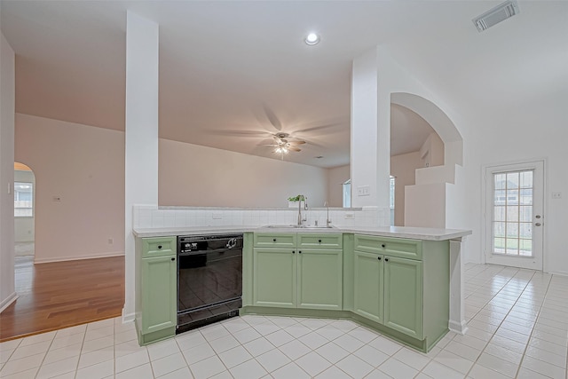 kitchen featuring decorative backsplash, black dishwasher, and green cabinetry