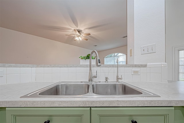 kitchen featuring vaulted ceiling, green cabinets, and sink