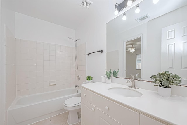 full bathroom with vanity, tile patterned flooring, ceiling fan, tiled shower / bath combo, and toilet