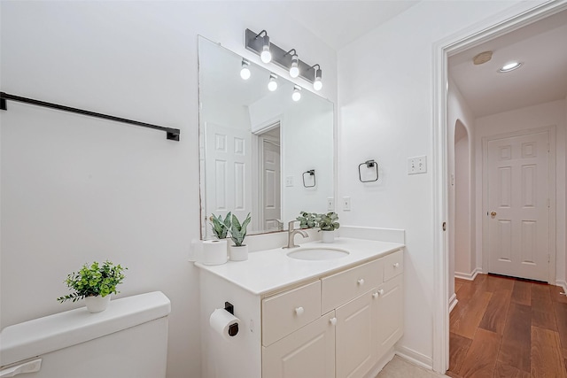 bathroom featuring hardwood / wood-style floors, vanity, and toilet