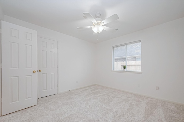 unfurnished room with ceiling fan and light carpet