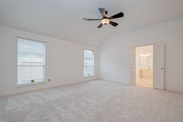 carpeted empty room featuring plenty of natural light, ceiling fan, and lofted ceiling