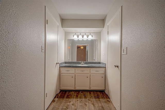 bathroom with vanity, hardwood / wood-style flooring, and ceiling fan