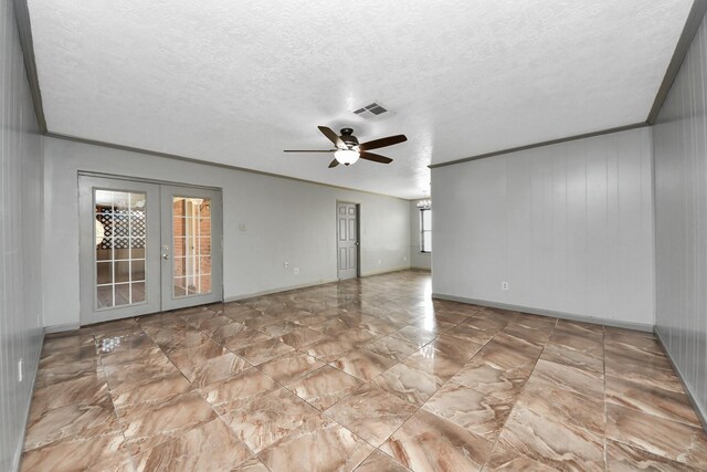 unfurnished room featuring ornamental molding, wood walls, ceiling fan, and french doors