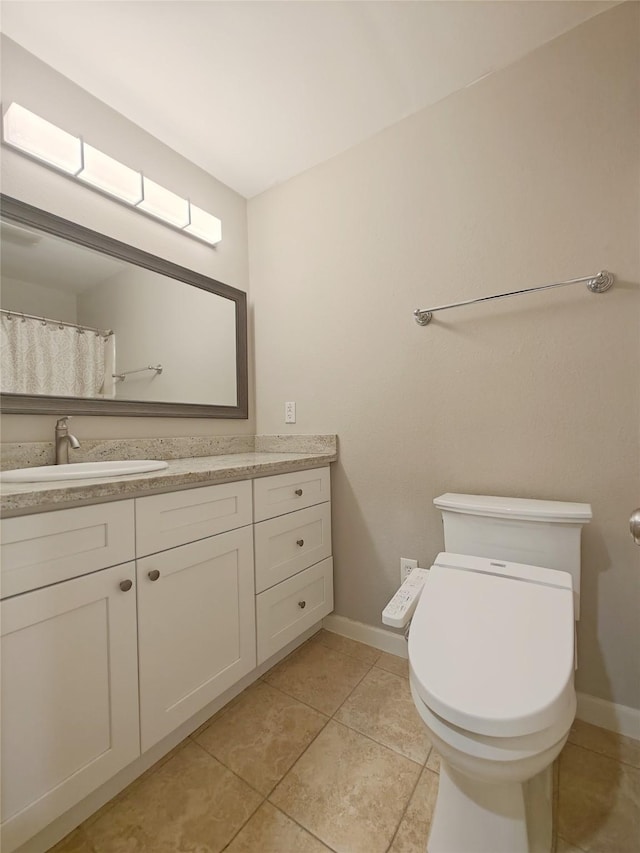 bathroom featuring tile patterned flooring, vanity, and toilet