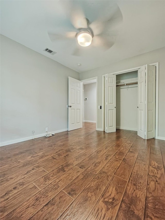 unfurnished bedroom featuring ceiling fan and dark wood-type flooring