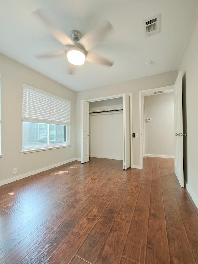 unfurnished bedroom featuring ceiling fan and dark hardwood / wood-style floors