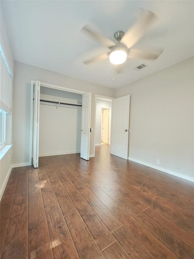 unfurnished bedroom featuring a closet, ceiling fan, and dark hardwood / wood-style flooring