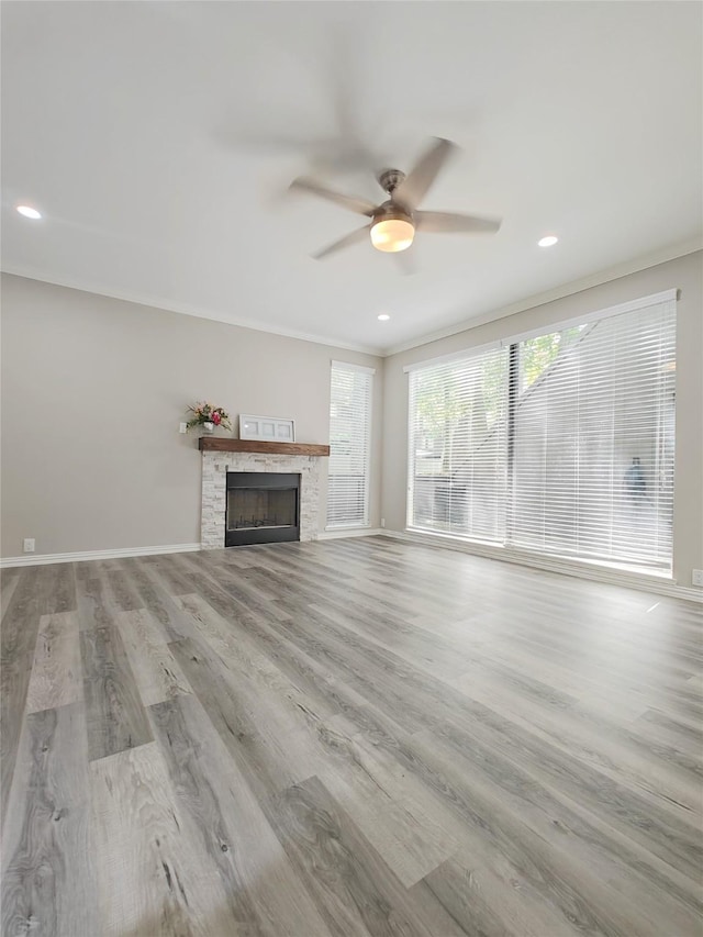 unfurnished living room featuring a fireplace, light hardwood / wood-style flooring, ceiling fan, and ornamental molding