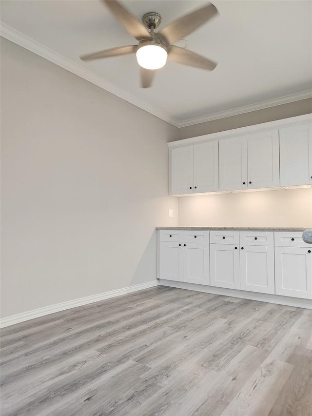 interior space with white cabinets, ceiling fan, light wood-type flooring, and ornamental molding