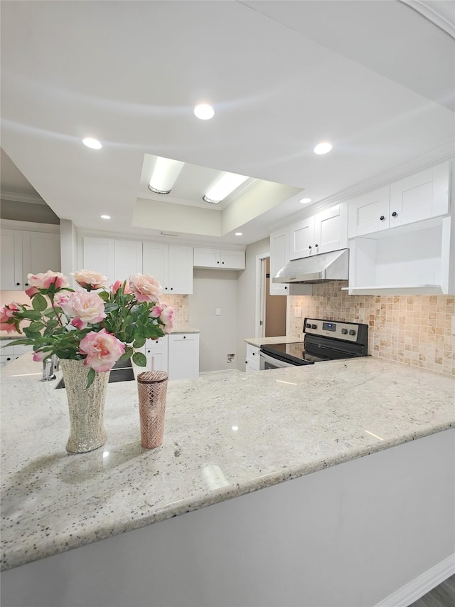 kitchen with a raised ceiling, kitchen peninsula, white cabinets, and stainless steel electric stove