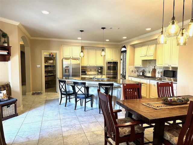 tiled dining room featuring sink and ornamental molding