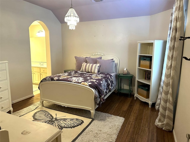 bedroom featuring dark hardwood / wood-style flooring, an inviting chandelier, and ensuite bath