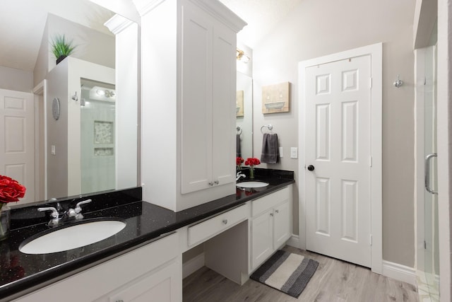 bathroom featuring lofted ceiling, wood-type flooring, and vanity