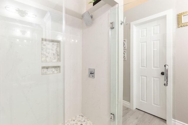 bathroom featuring a shower with door and hardwood / wood-style floors