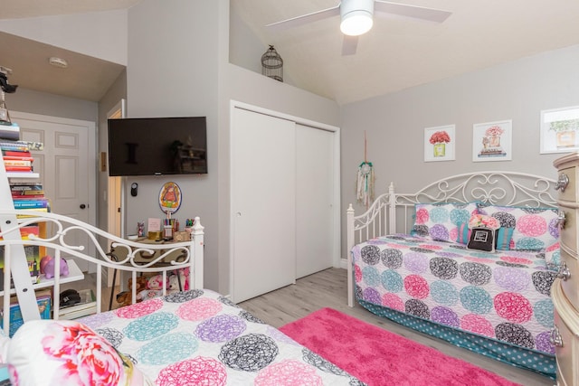 bedroom featuring ceiling fan, light hardwood / wood-style floors, a closet, and vaulted ceiling