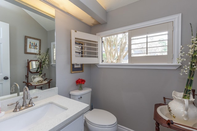 bathroom featuring lofted ceiling, vanity, and toilet