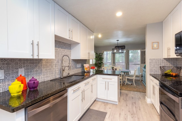 kitchen featuring light hardwood / wood-style flooring, decorative light fixtures, white cabinets, appliances with stainless steel finishes, and sink