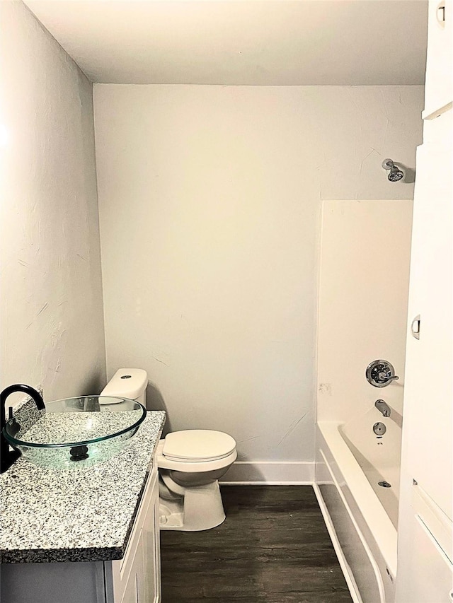 full bathroom with hardwood / wood-style floors, vanity, toilet, and shower / washtub combination