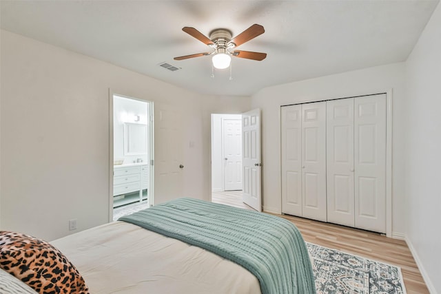 bedroom featuring hardwood / wood-style floors, ceiling fan, connected bathroom, and a closet