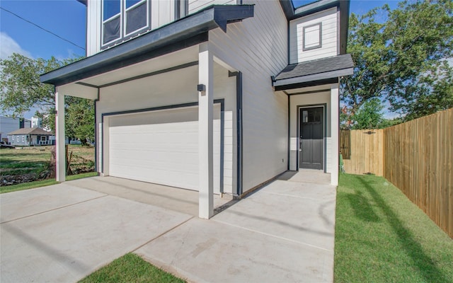 property entrance featuring a lawn and a garage