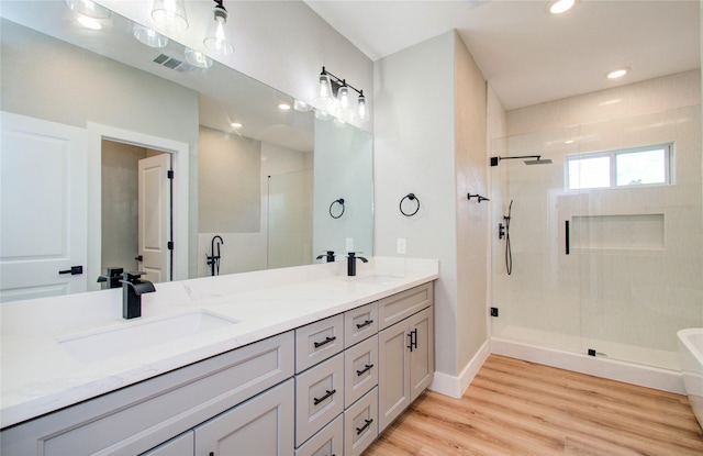 bathroom with separate shower and tub, vanity, and hardwood / wood-style flooring