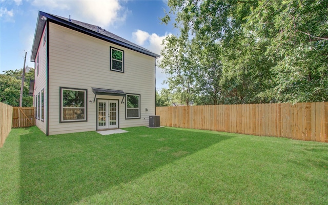 back of property featuring a lawn, french doors, and central AC unit