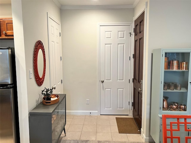 foyer entrance featuring crown molding and light tile patterned floors