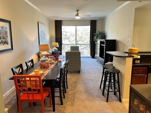 carpeted dining space with ceiling fan and ornamental molding